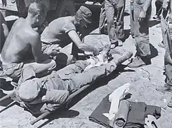 A Hospital Corpsman prepares a wounded Marine for evacuation from a forward aid station in the Yanggu area.