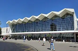 Entrance to the Novi Sad railway station showing its front facade, including the overhanging portion of the roof and the suspended canopy.