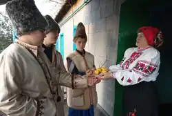 A woman giving fruits and nuts as a gift to boys at the doorstep