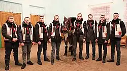A group of men in traditional costumes and a horse