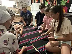 Adults and children playing a game of knucklebones