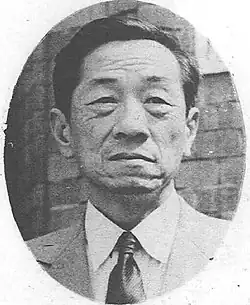 Asian man facing front, in suit and tie.