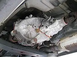 Center transfer case sending power from the transmission to the rear axle (right) and front axle (left)