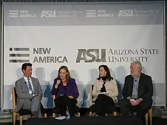 A photograph of four panelests seated in chairs in front of a New America / Arizona State University banner