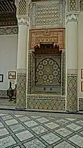 Ornate wall fountain in the main courtyard, with painted wood and zellij decoration