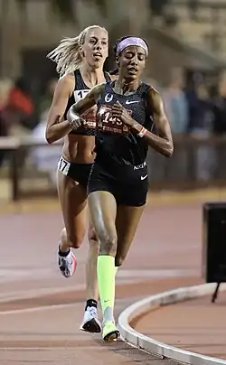 Hassan races in front of another woman in a track.