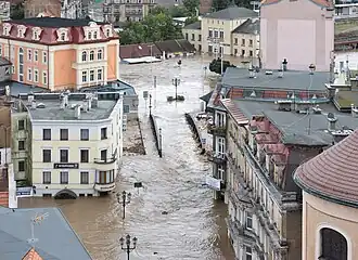 Flooded Iron Bridge in Kłodzko, Poland, surrounded by flooding across multiple buildings