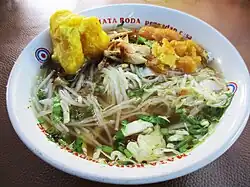 Soto, a traditional soup made with rich broth, tender meat, and fresh vegetables, often served with rice and various toppings.