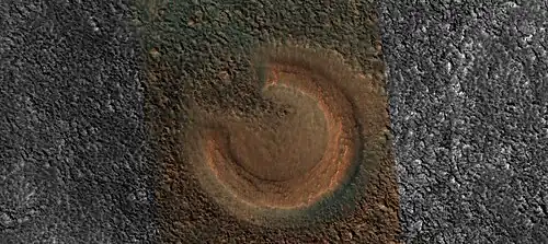 Close view of mud volcano, as seen by HiRISE. Picture is about 1 km across. This mud volcano has a different color than the surroundings because it consists of material brought up from depth. These structures may be useful to explore for remains of past life since they contain samples that would have been protected from the strong radiation at the surface.