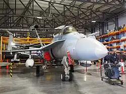 Colour photo of a grey aircraft in a building