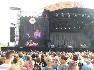 A group of musicians performing on stage in front of a crowd.