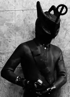 An alien creature in a rubber wetsuit