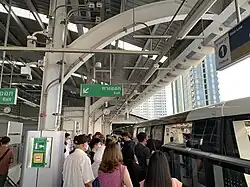 Passengers waiting to enter the train at Krung Thon Buri station.