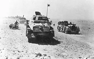 Armored vehicle convoy moving through a dessert