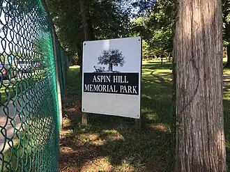 A cemetery sign adjacent to a perimeter fence