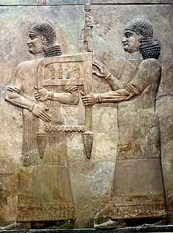 Assyrian attendants carrying the throne of Sargon II, part of a tributary scene from Khorsabad, Iraq. Iraq Museum