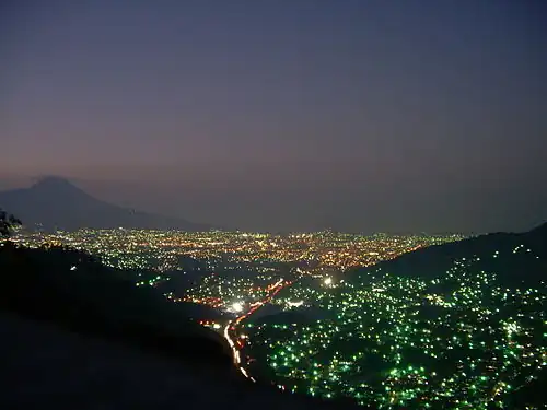 San Salvador volcano towering over San Salvador city at night