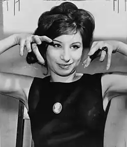Singer and actress Barbra Streisand in 1962 wearing a top with a crew-neck. Her hair is teased at the crown.