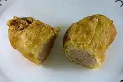 A battered sausage, sliced in half after cooking