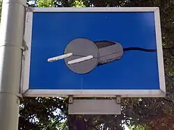 Blue sign depicting a gray electrical plug