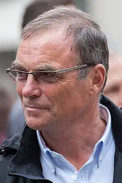 Color photograph of Hinault, looking to the left, wearing glasses