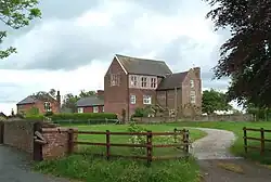 Bettisfield Hall Farm, with a house at the centre and a path towards it.
