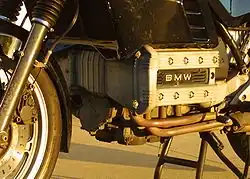 Closeup picture of BMW K100 engine. Also shows some black bodywork, forks and a front brake caliper