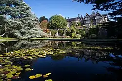 a pond overlooked by a formal terrace and country house