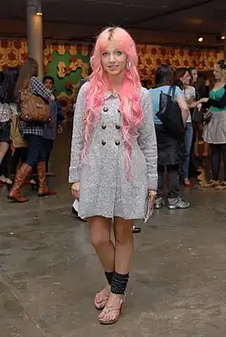 Brazilian girl wearing leg warmers, knitted sweater dress, and pastel hair, blending retro and alternative aesthetics into hipster style, 2011.