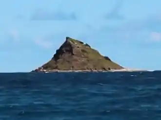 A conical islet rising out of the ocean.