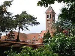 Abbey building with a bell tower with some trees in front
