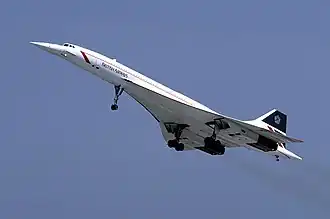 Concorde against a clear blue sky, seen from below. Its wheels are lowered.