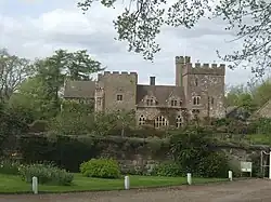 A large house with crenellated towers, set in walled garden.