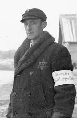 A camp policeman at Salaspils concentration camp with an armband saying "Chief Jewish Camp Policeman"