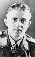 A man wearing a military uniform with an Iron Cross displayed at his neck.