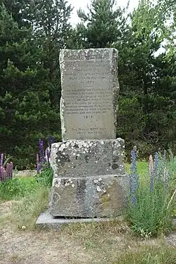 A stone slab monument in a forested area