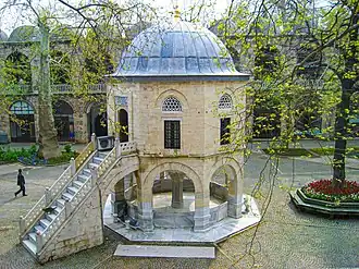 Courtyard of the Koza Han in Bursa, Turkey (1491, Ottoman period) ; the domed building is a small mosque[48]