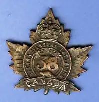 Battalion cap badge, featuring maple leaf and number 38