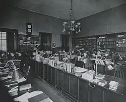 Black-and-white photo of a room with rows of long desks