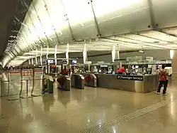 The concourse area at the platform level. A set of faregates separate the paid and unpaid areas.