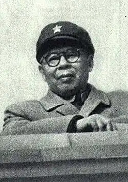 Black and white headshot of Boda in glasses and a cap with a star