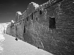 A black-and-white picture of a long brick wall