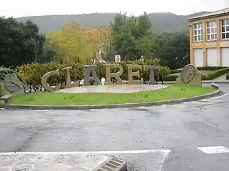 Sculpture made by a local craftsman in local quarry stone at the entrance of the village, before the bridge over the Brestalou. In the background is the Crête de Taillade.