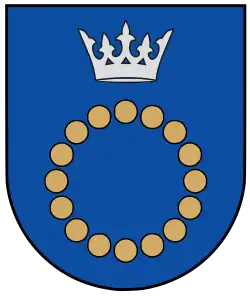 A coat of arms depicting a circle for which the boundary is itself made up of beige circles all under a silver crown on a blue background