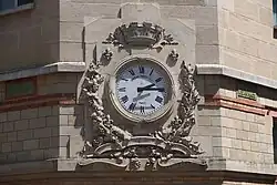 Clock on the facade of the school, long stopped.