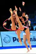 Two gymnasts passing through a hoop during a group exercise (Spanish group)