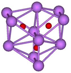 The ball-and-stick diagram shows three regular octahedra where each octahedron is connected to both of the others by one face each. All three octahedra have one edge in common. All eleven vertices of the structure are violet spheres representing caesium, and at the centre of each octahedron is a small red sphere representing oxygen.