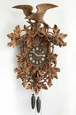 Carved wall timepiece, weight-driven, Black Forest, c. 1900. Carved cuckoo clocks evolved from the Bahnhäusle style (Deutsches Uhrenmuseum, Inv. 2006–015).