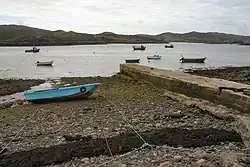 Photograph of the Culkein Drumbeg jetty and several small boats in the water