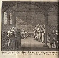 Four people writing behind a turbaned man in talks with a group of representatives.